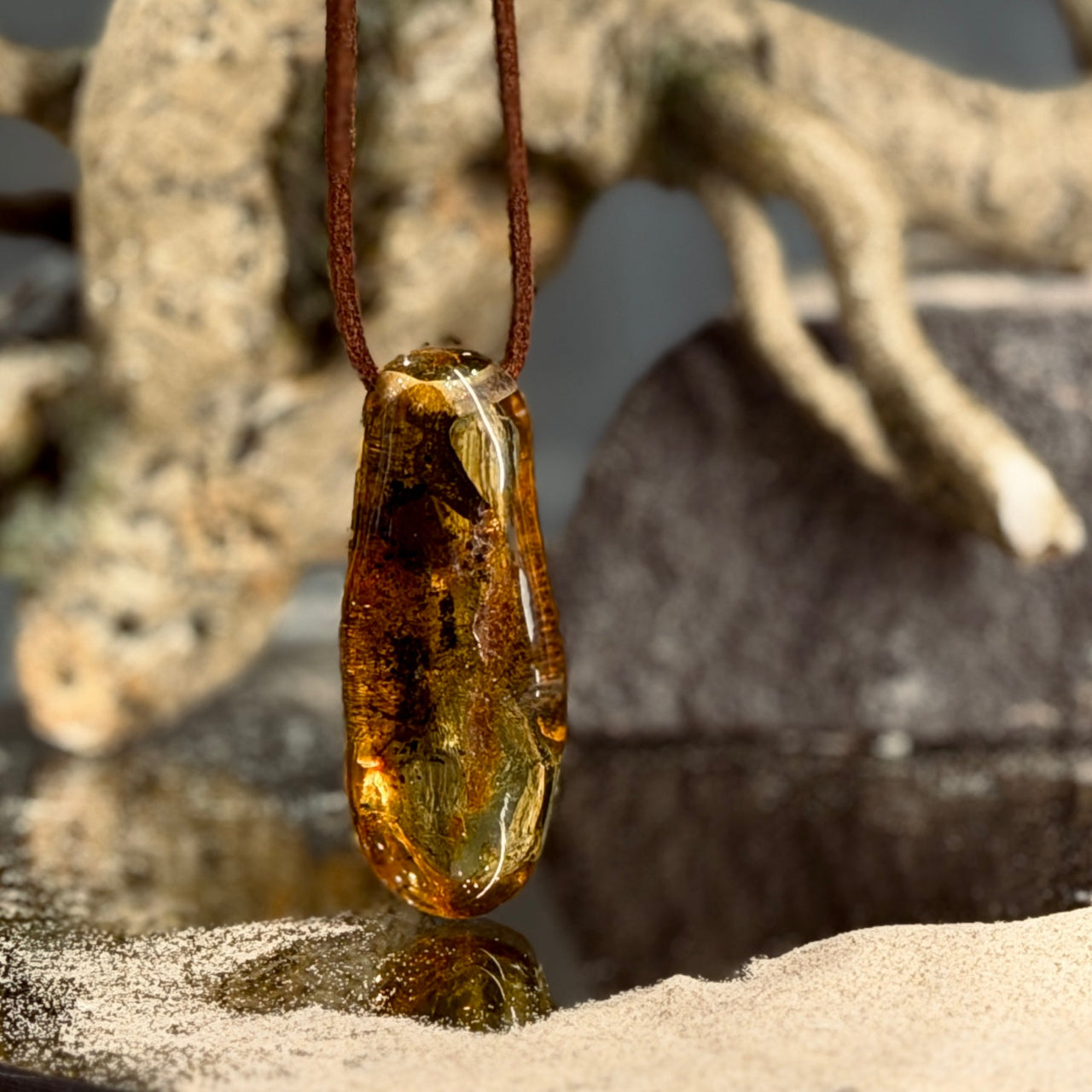 DZINTARA kuloni ādas aukliņā